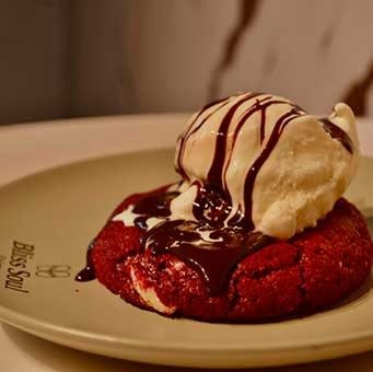 Cookie Bliss tibia de Red Velvet con helado artesanal de vainilla y salsa fudge de chocolate caliente en Bliss Soul Bakery Sabaneta